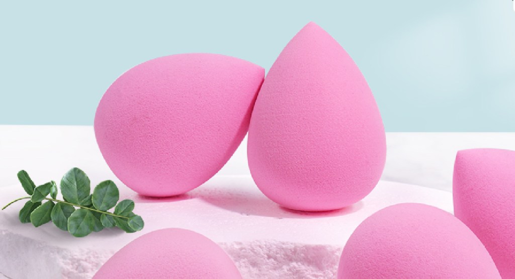 display of pink makeup sponges with flower next to it