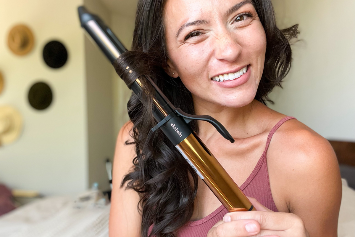 woman using curling iron on hair