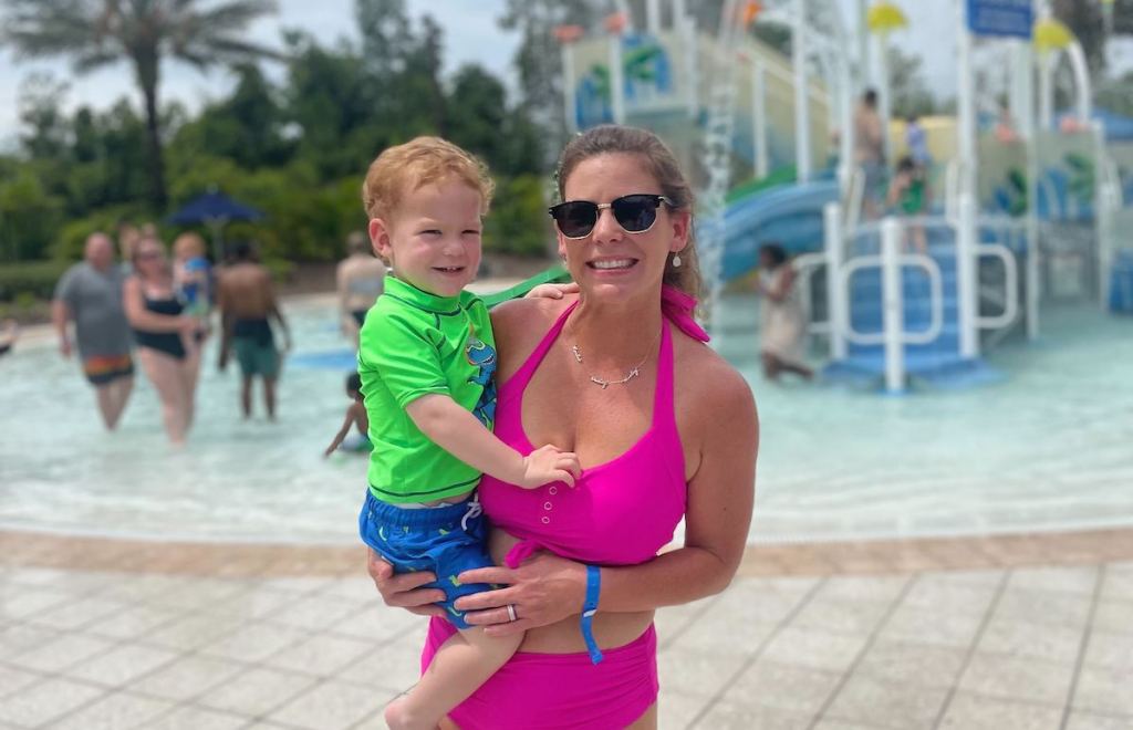 woman holding baby standing at waterpark