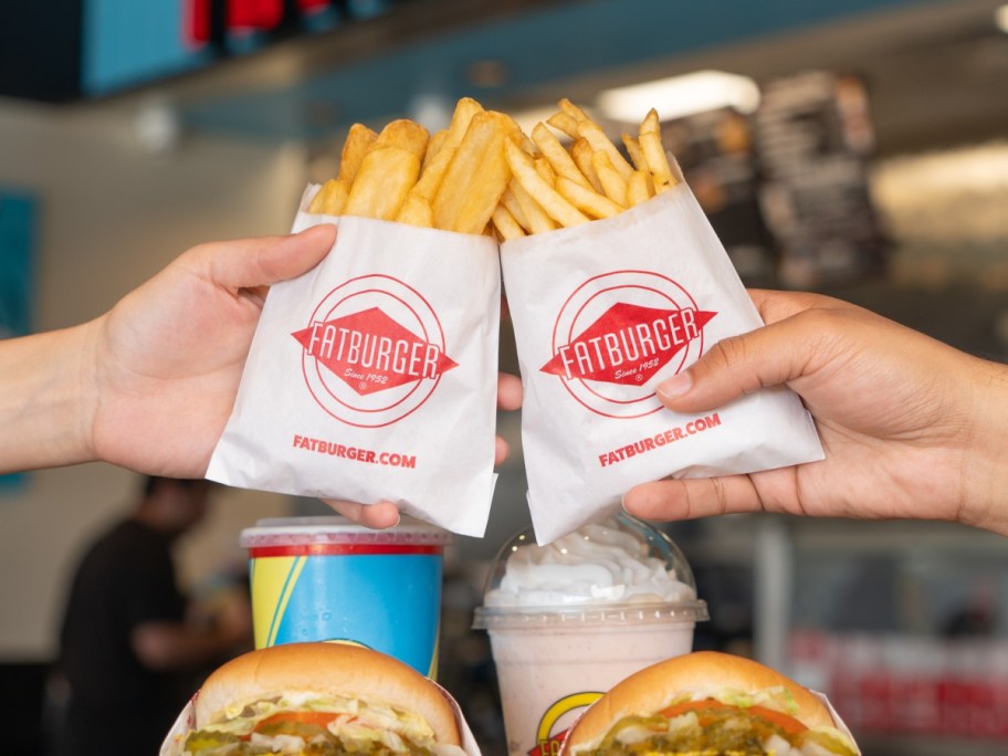 two hands holding Fatburger fries