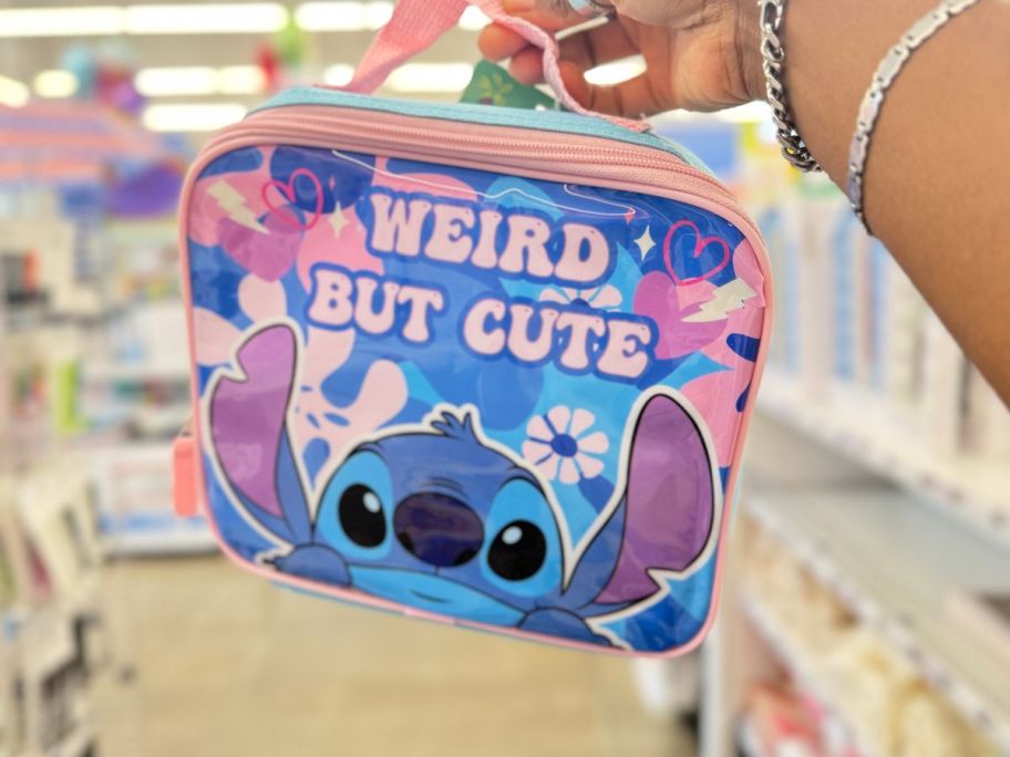 Disney Stitch 'Weird But Cute' Lunch Bag being held by hand in store