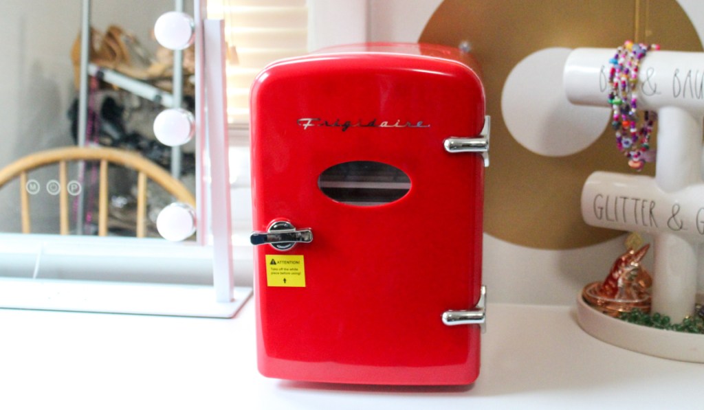 small red mini fridge near jewelry holder and mirror