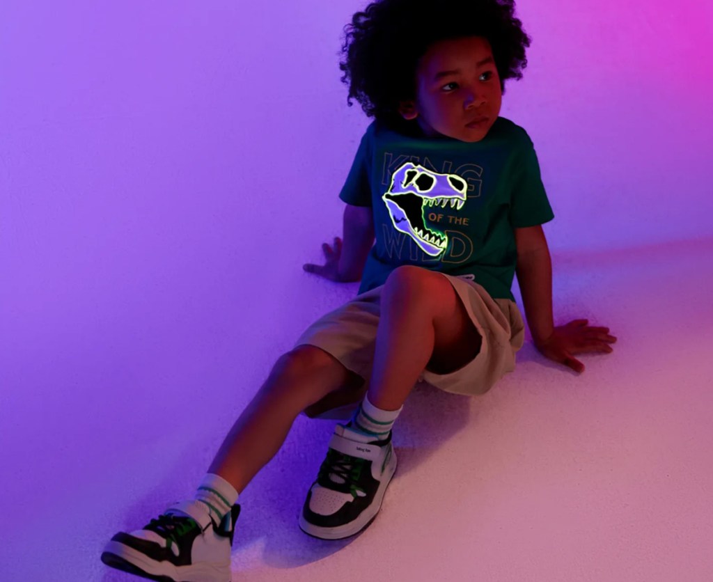 boy sitting on floor with light up shirt