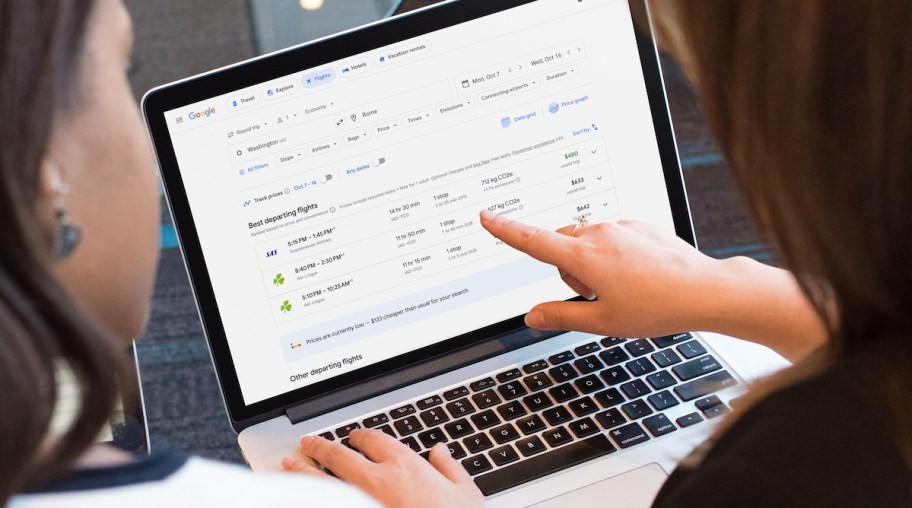 hand pointing to laptop screen with google flight prices to italy