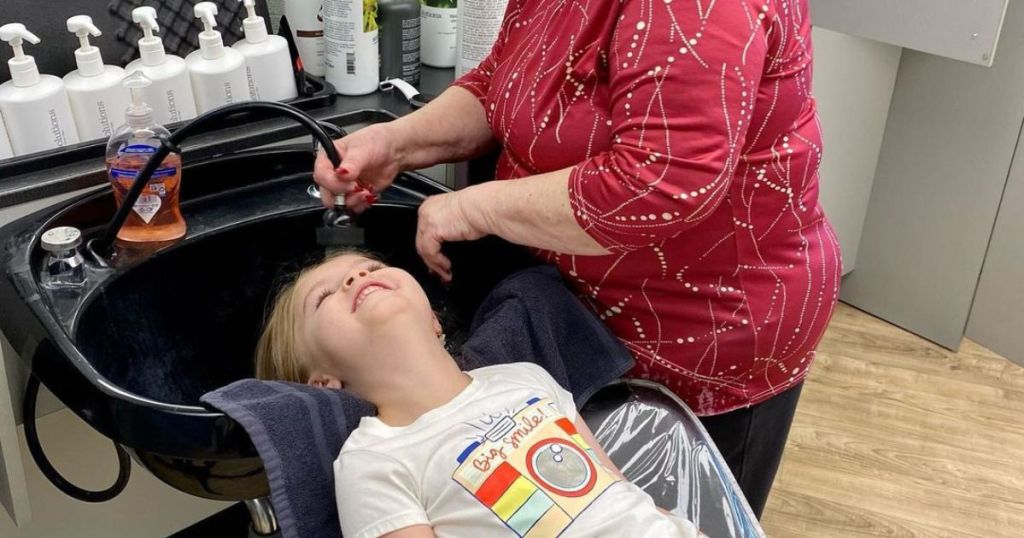 little kid getting hair washed at salon