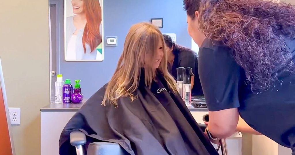 little girl wearing great clips cape getting hair cut