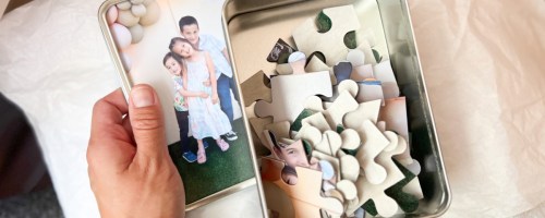 hand holding Walgreens photo puzzle keepsake with tin and puzzle inside