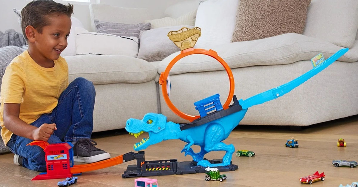 boy playing with trex hot wheels track set
