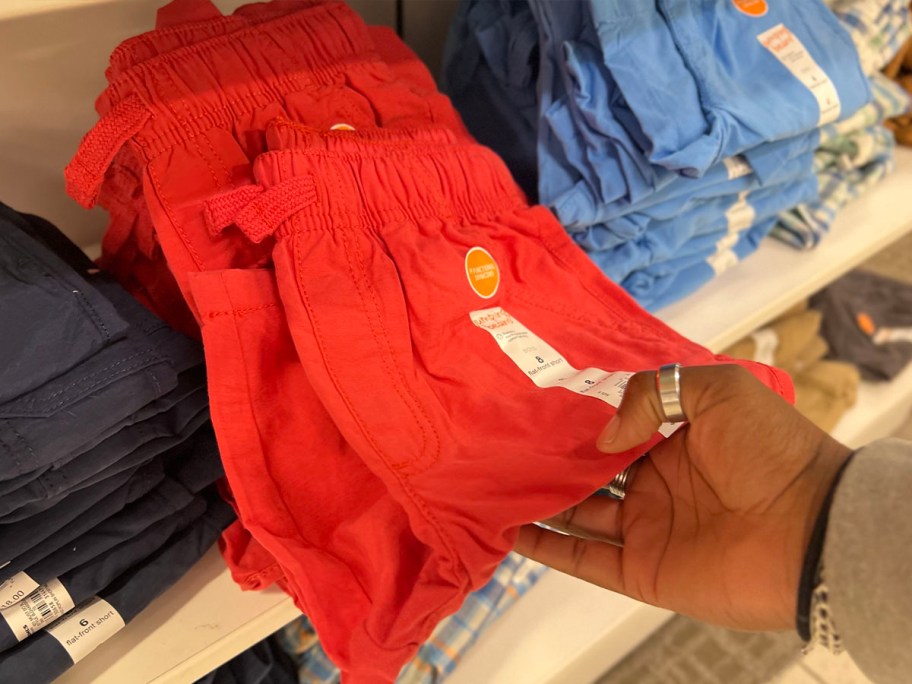 hand picking up red shorts