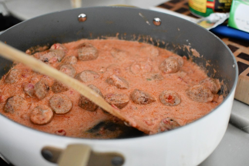 mixing Boursin cheese and tomato sauce