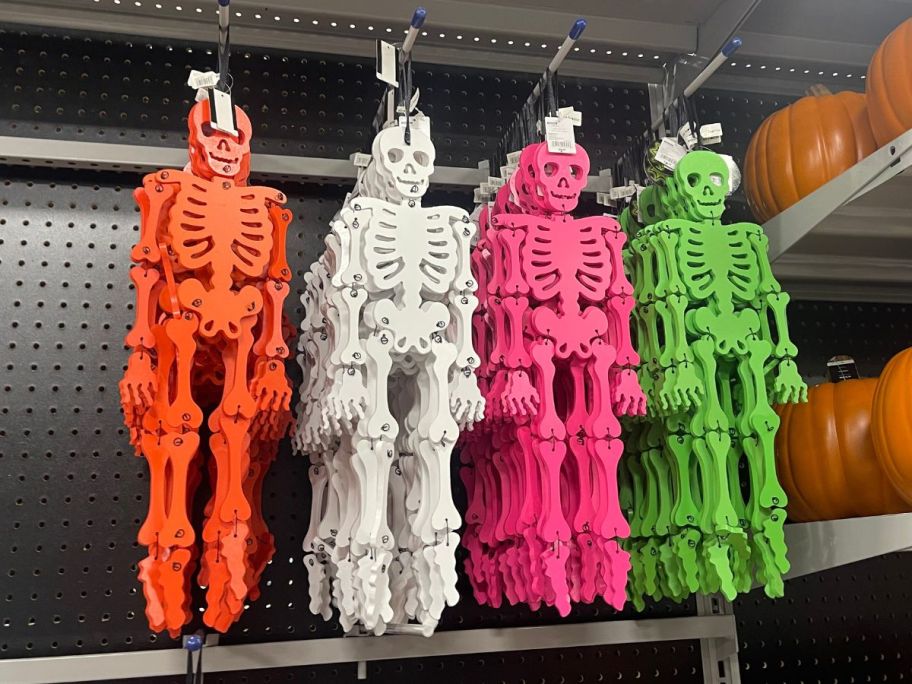 a selection of neon colored skeletons hanging on a store shelf