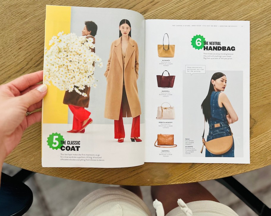 hand holding nordstrom anniversary sale magazine open with fall jackets