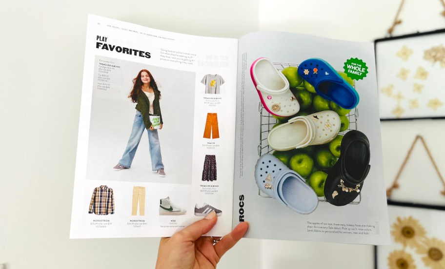 hand holding a nordstrom anniversary sale magazine with kids deals