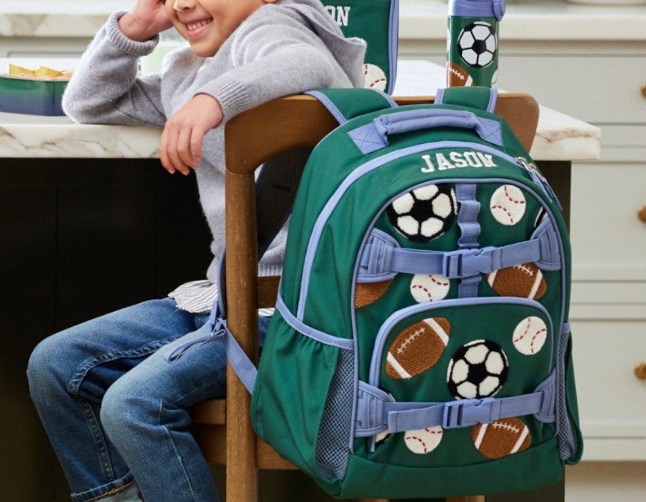 kid sitting in chair with personalized soccer backpack on seat