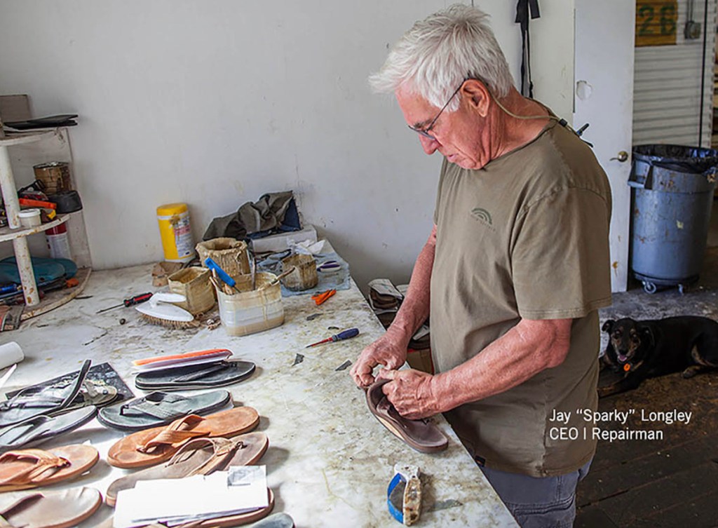 man standing in shoe repair workshop fixing flip flop