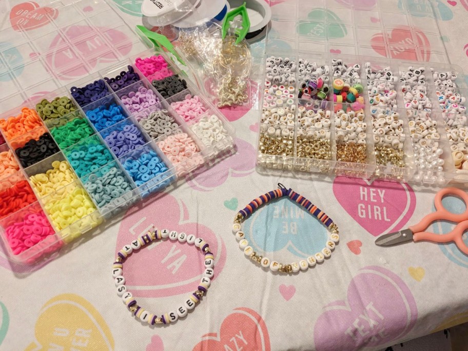 multicolored bead making kit and alphabet kit sitting on table with bracelets