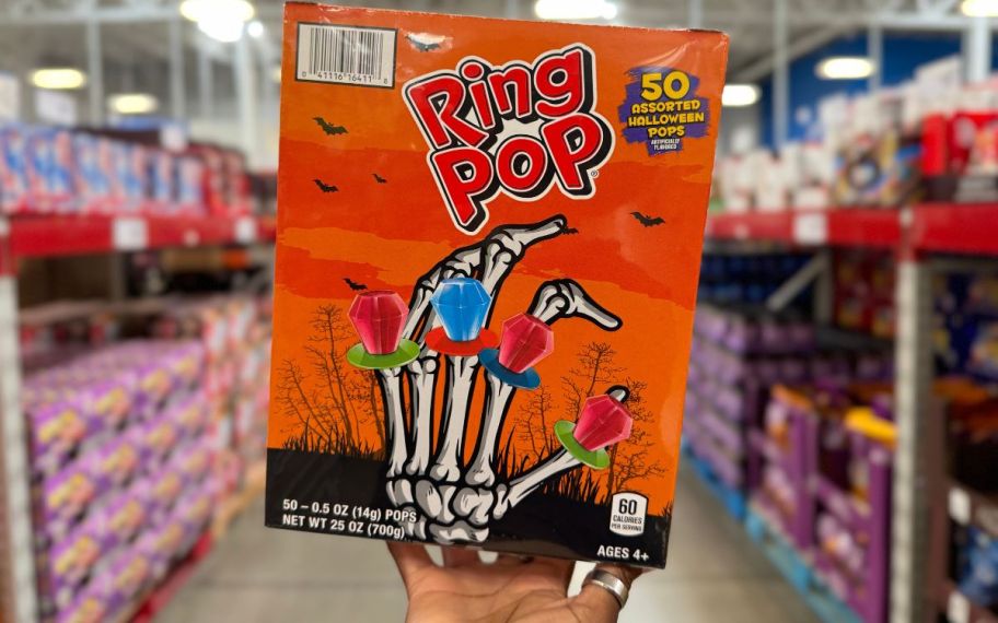 a womans hand holding a 150 count bag of ring pops