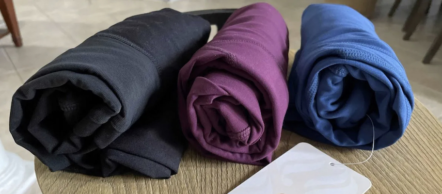 rolled clothing on wood table travel packing hacks