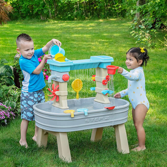 kids playing with a step2 water table outside