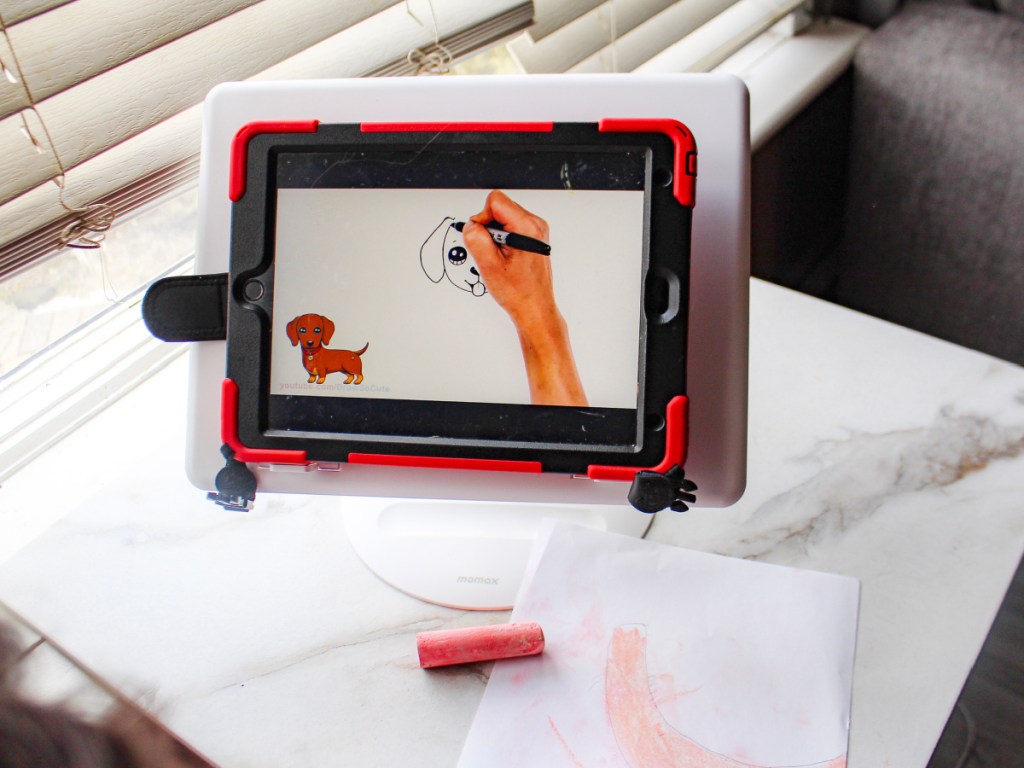 tablet stand with tablet on it on the table with little girl writing on desk-2