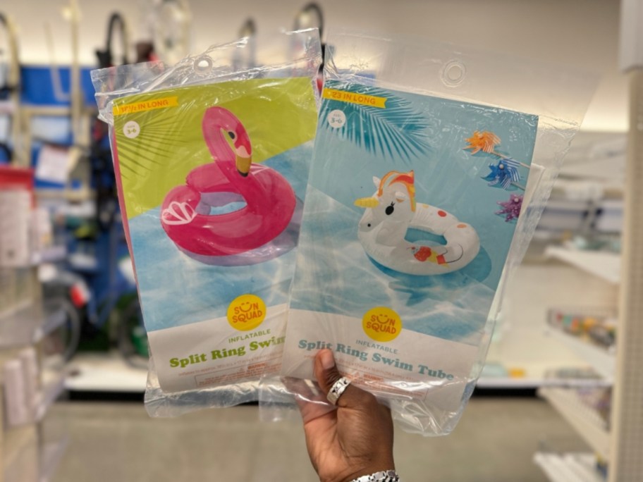 hand holding kids pink flamingo and unicorn pool ring floats