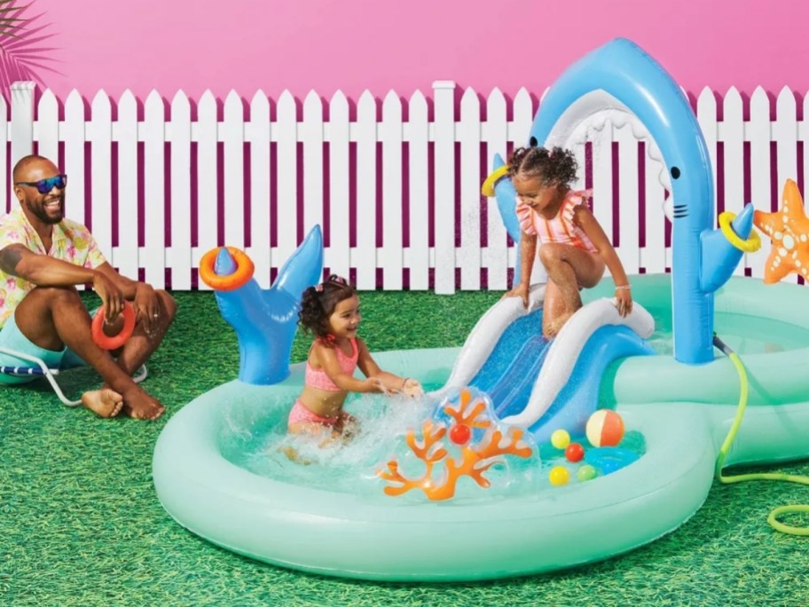 kids playing in a Shark themed inflatable pool with slide 