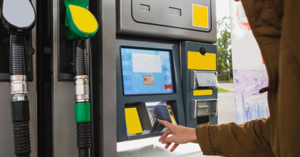person at gas pump selecting gas type