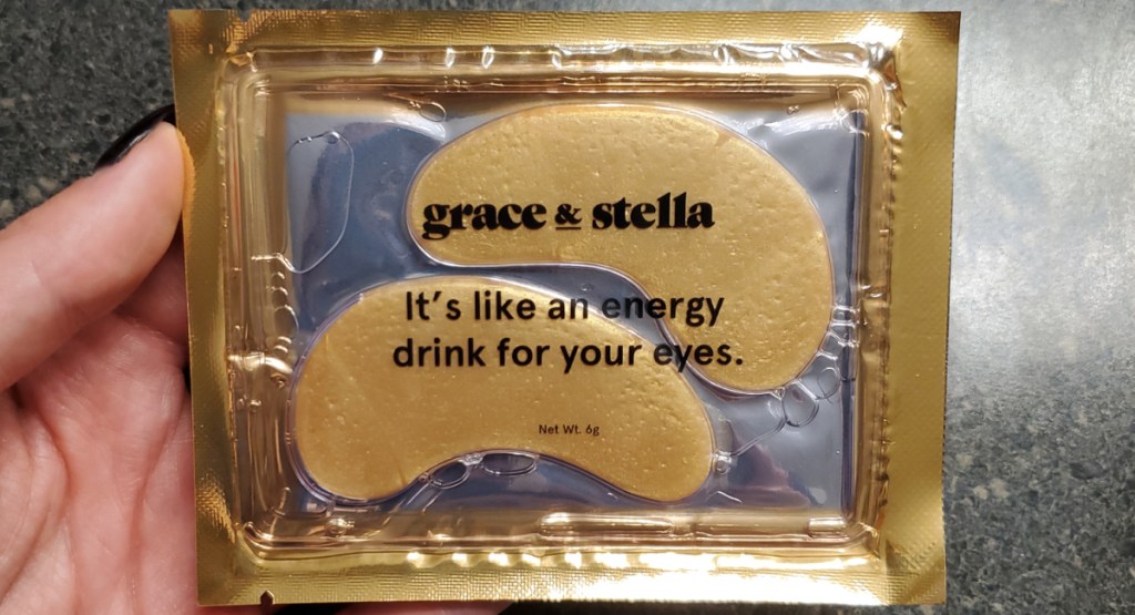 woman holding Grace & Stella Under-Eye Gold Mask in its package