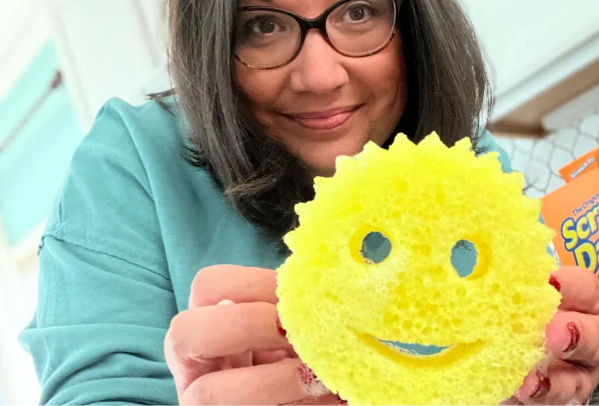 woman holding a yellow scrub daddy sponge