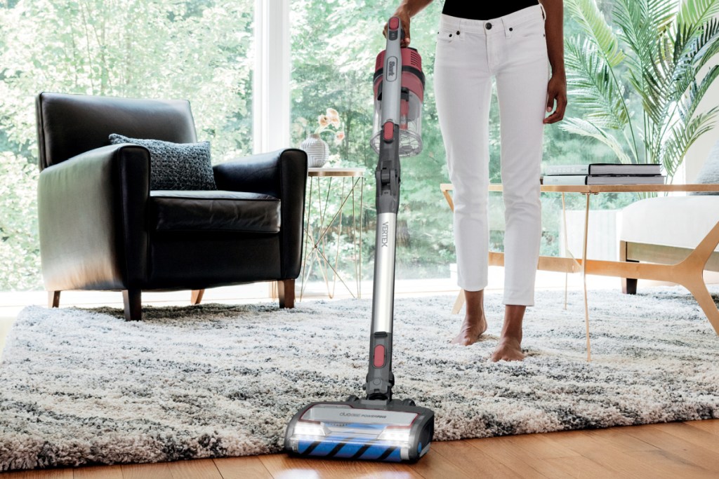 woman using vacuum on floor & carpet