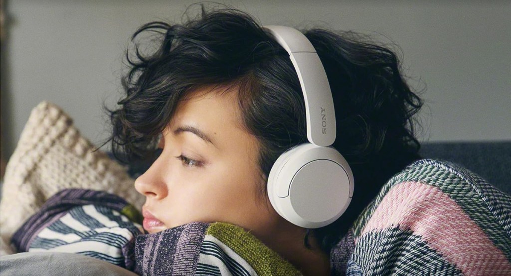 woman wearing Sony Bluetooth Wireless Headphones with Microphone as she lays in bed