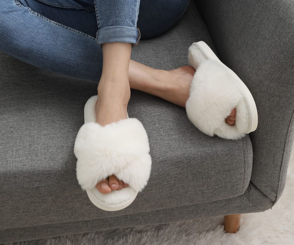 woman wearing white fuzzy slippers on couch