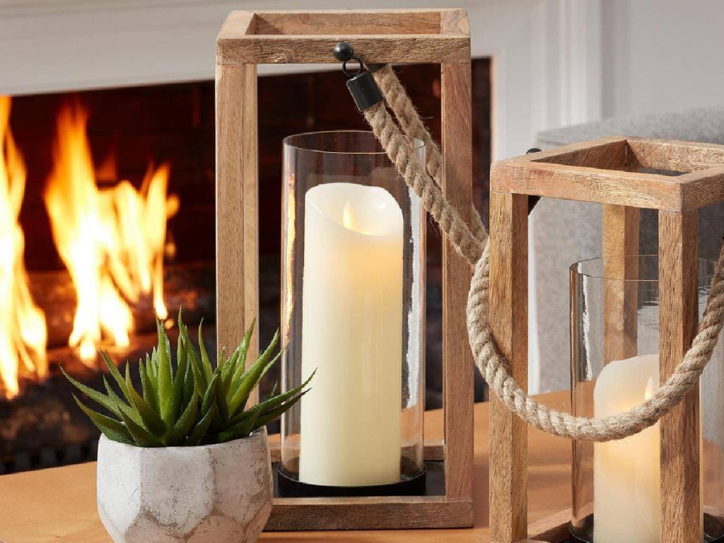 wood natural lanterns with candle inside and plant next to it