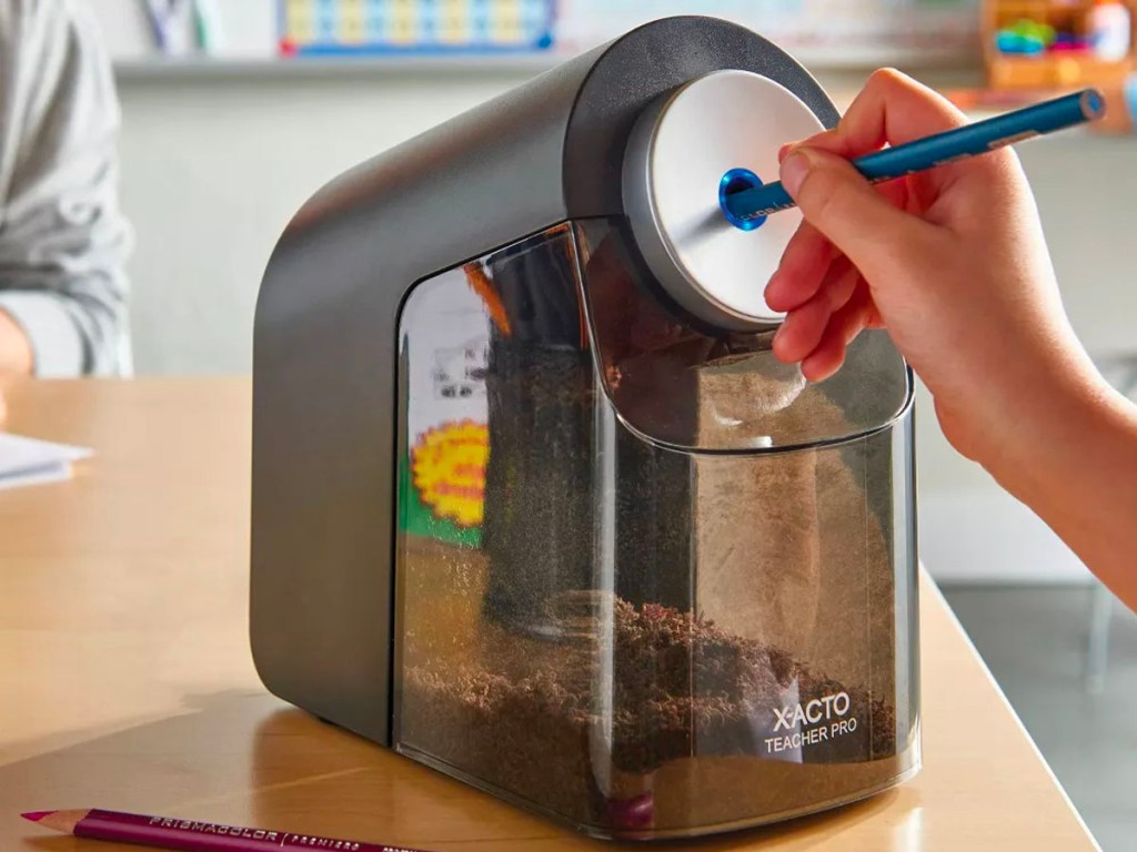 child sharpening pencil in electrice pencil sharpener