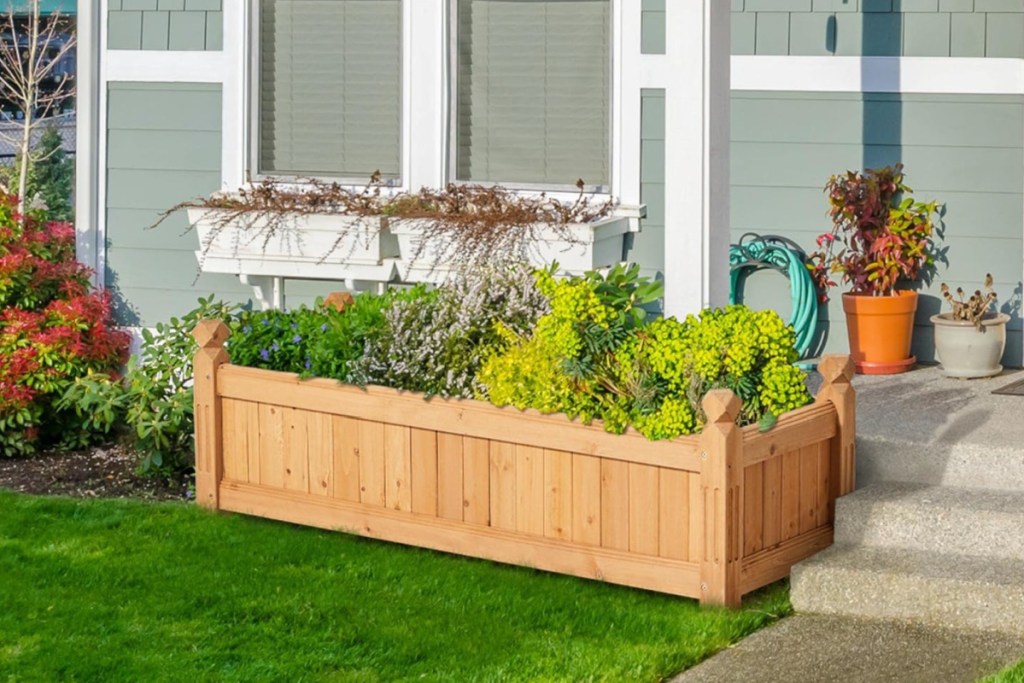 wooden paneled raised garden bed in front of house