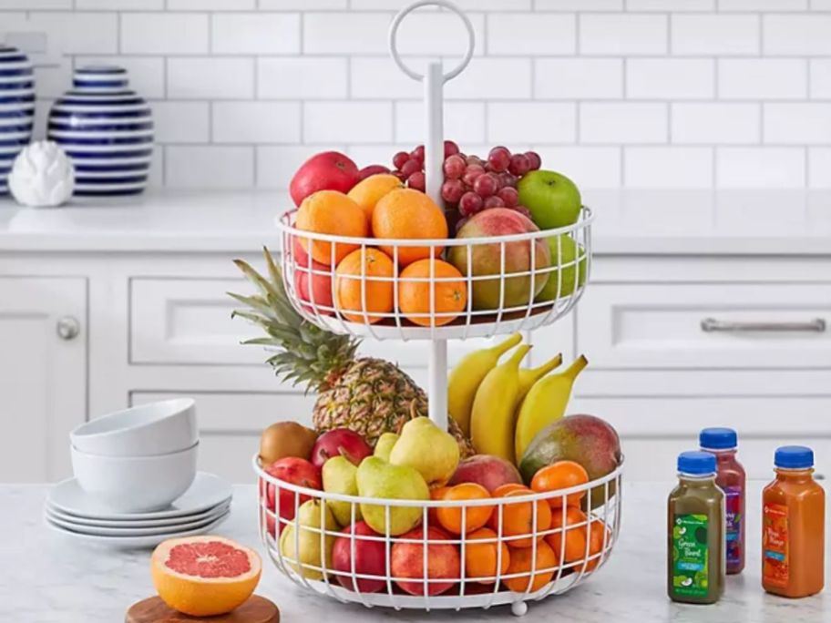 white 2 tier metal basket stand on kitchen counter filled with fruit