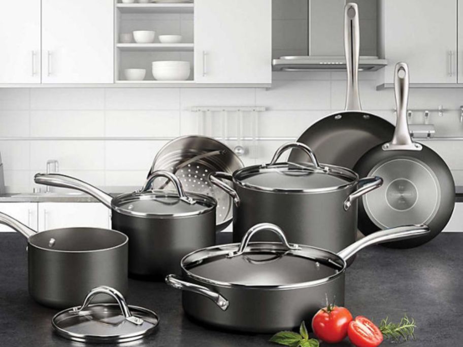 black and silver non-stick cookware set pots, pans and lids on counter