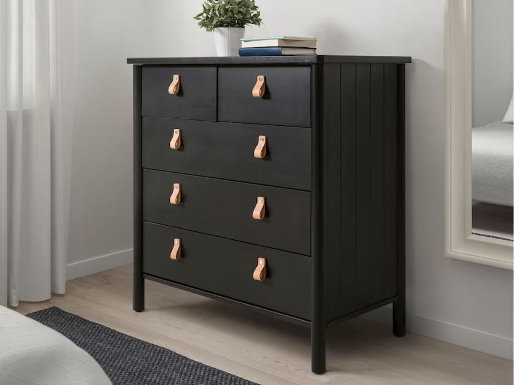 black five drawer dresser in bedroom