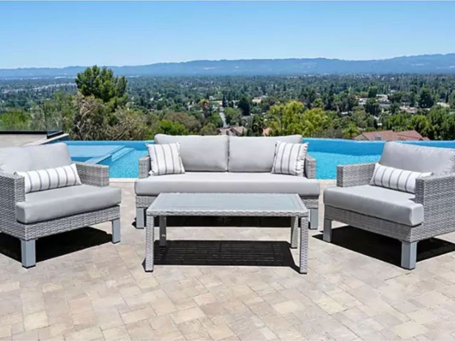 grey outdoor patio furniture set with pool in the background