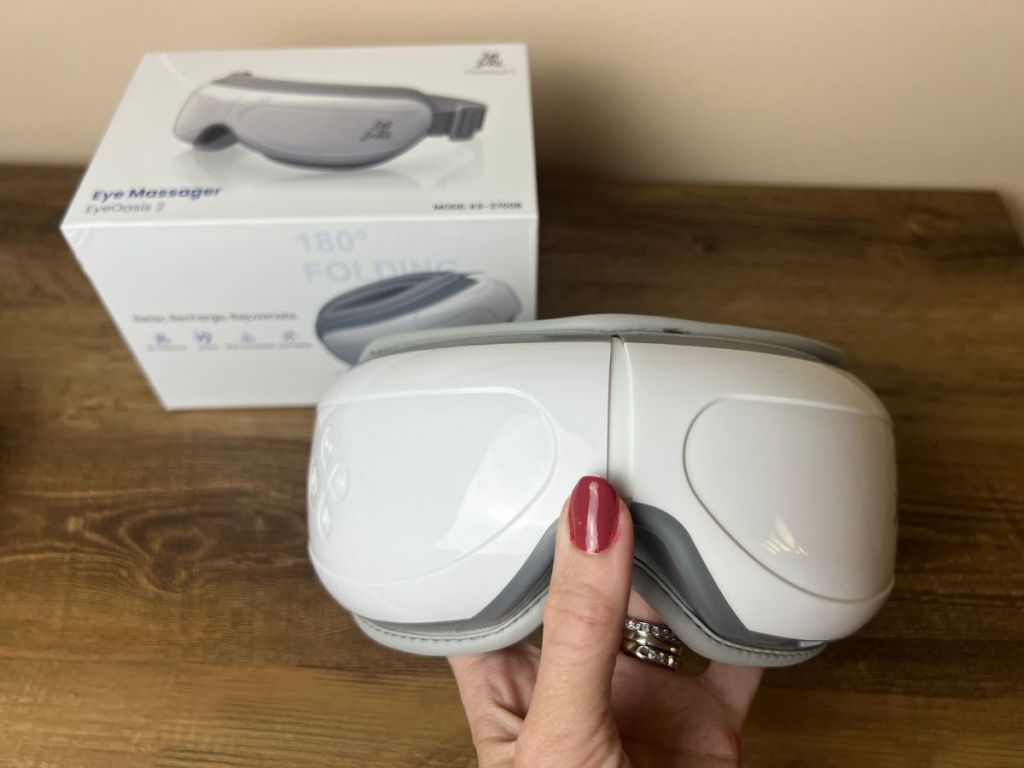 Bob & Brad EyeOasis 2 Heated Eye Mask Massager in woman's hand with box in the background