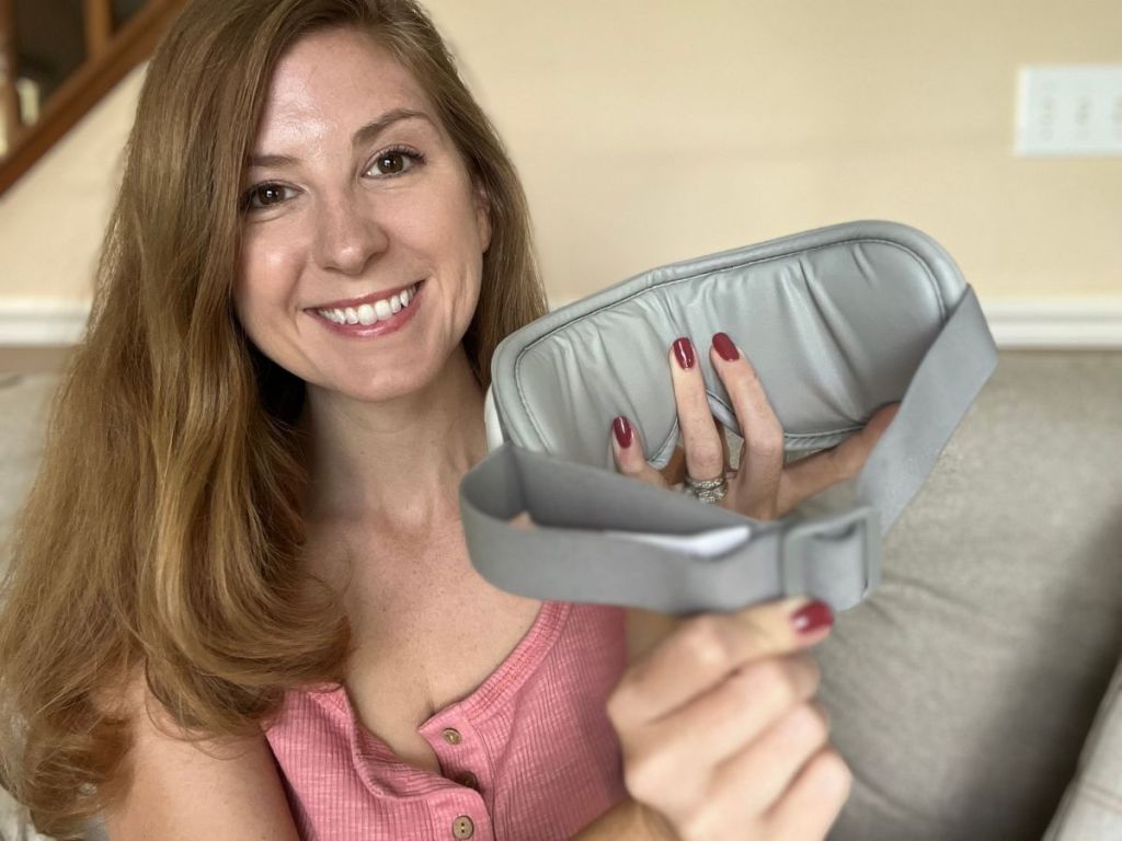 Woman holding and showing the inside of a Bob & Brad EyeOasis 2 Heated Eye Mask Massager
