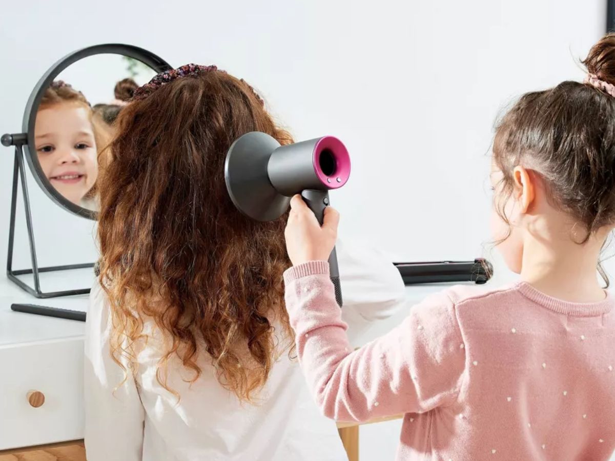 Little girls playing hair salon with a Casdon Toys Dyson Supersonic Styling Set