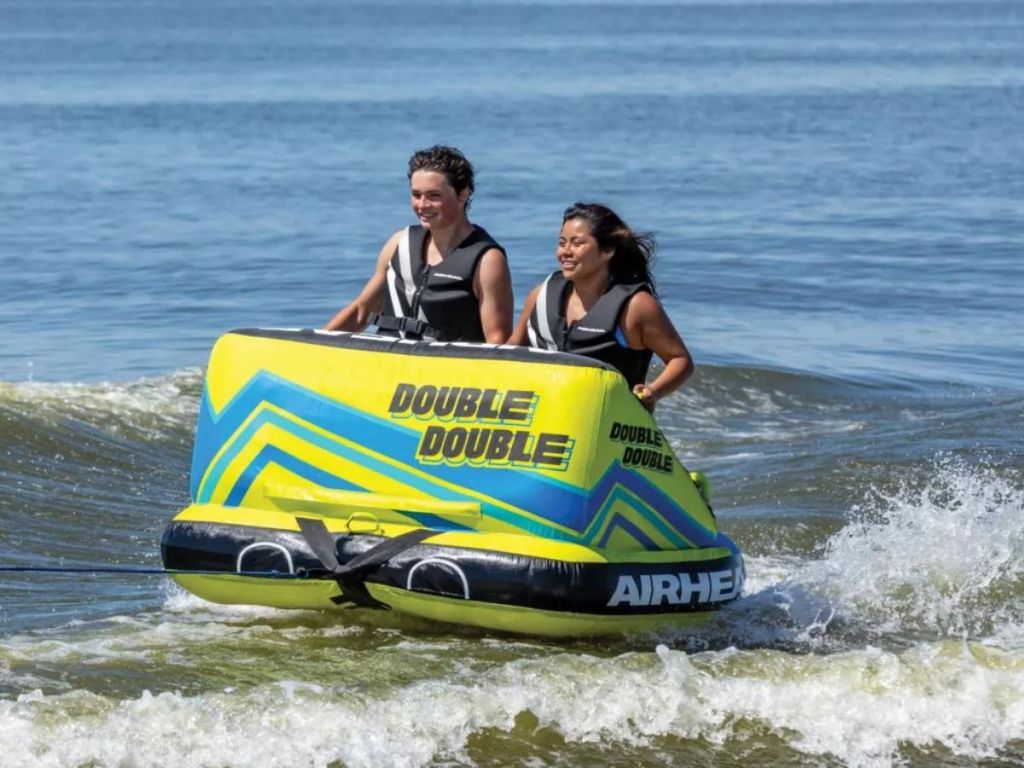 2 kids on the water in a towable tube 