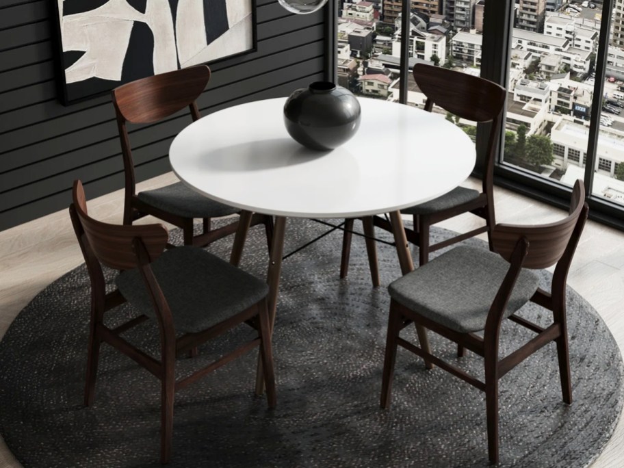 dark wood chairs around round white dining table