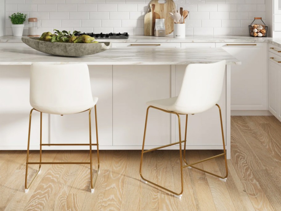 two white counter stools with gold legs in kitchen