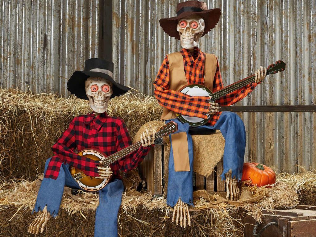 2 banjo playing skeletons halloween decor sitting on hay