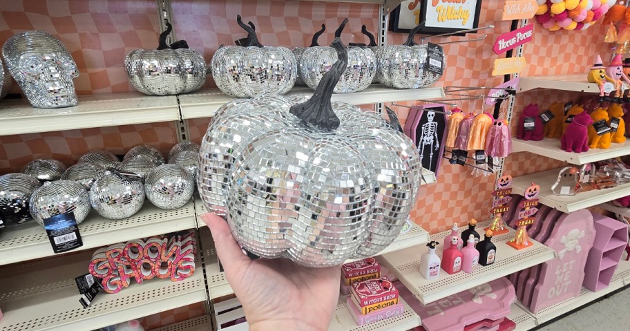 Ashland 8in Disco Ball Pumpkin Tabletop Decor being held in front of Michael's new Halloween decor