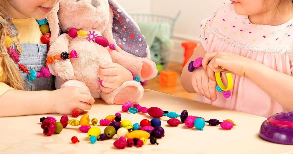2 children playing with snap beads