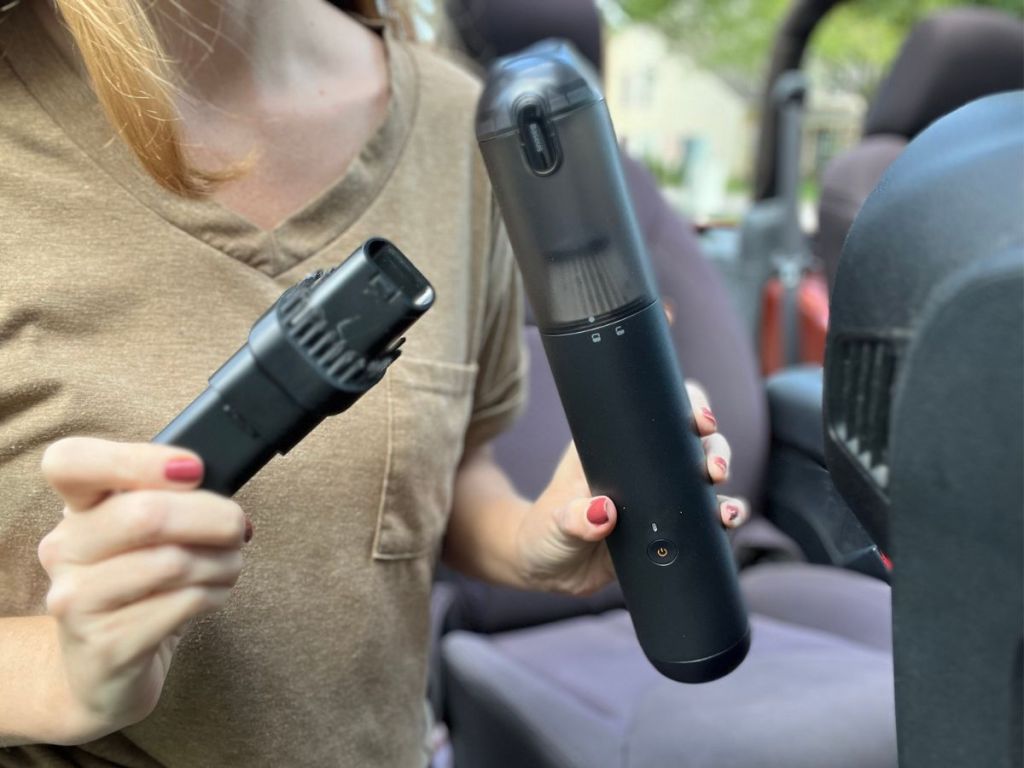 woman holding up vacuum and vacuum brush