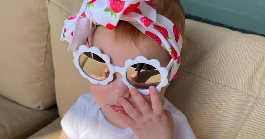 A baby wearing a pair of white sunglasses
